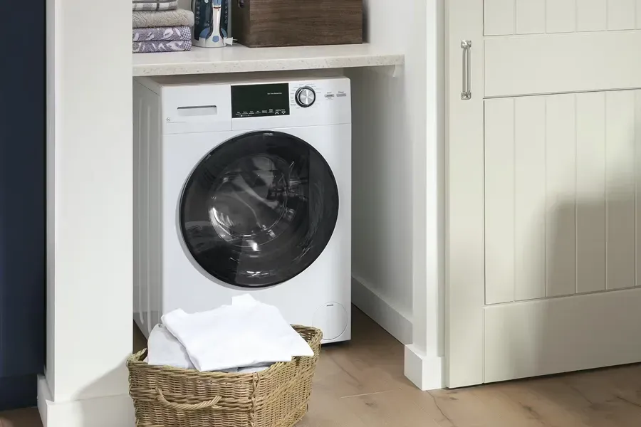 GE GFQ14ESSNWW white compact washer and ventless electric dryer combo unit under a countertop, ideal for saving space in small laundry areas.